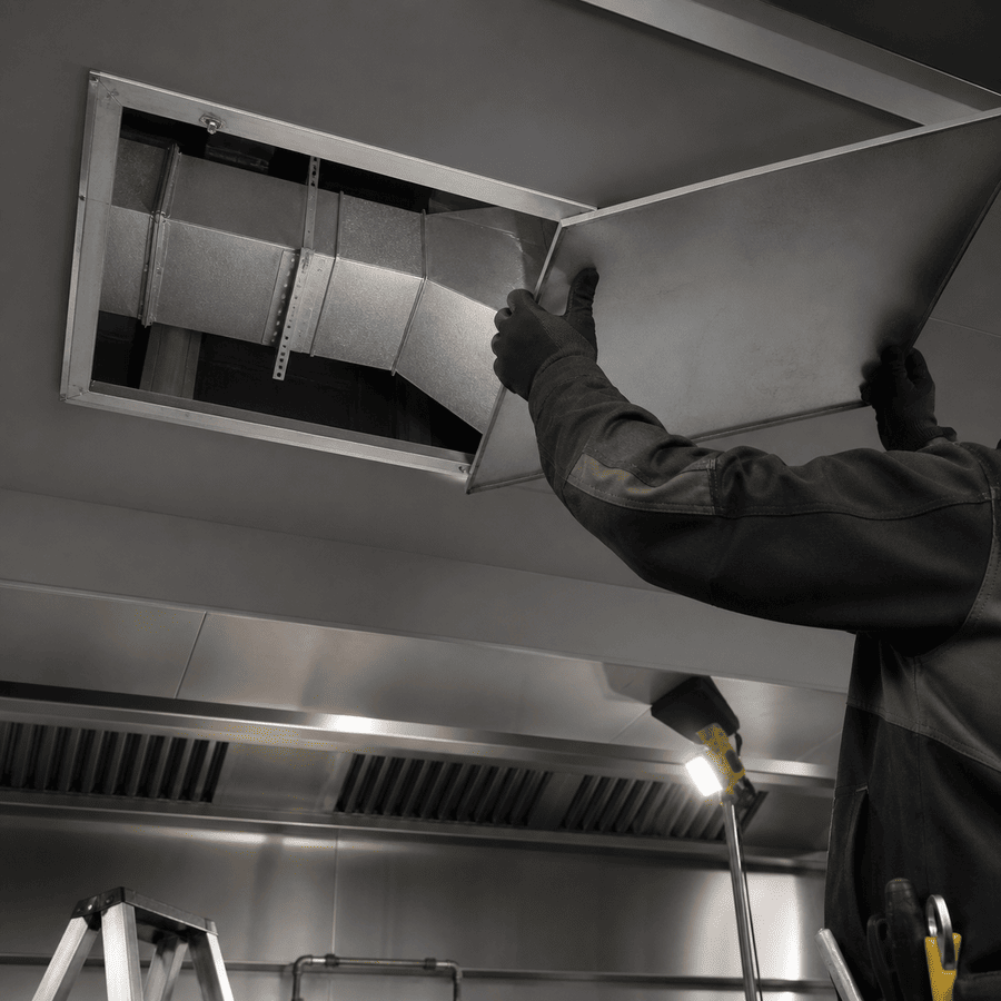 Open exhaust duct access panel above a commercial kitchen